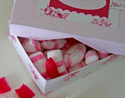 Karamellask i papp med polkagrisar som skymtar under locket