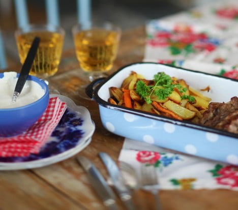 Uppdukat middagsbord med blommig duk och små glas på fot.