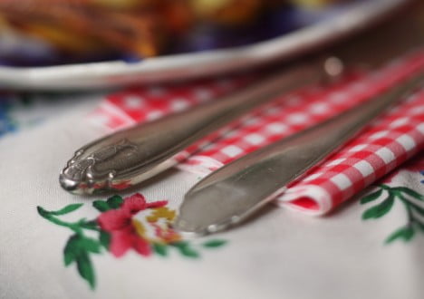 Dukat med silverbestik och rödrutiga servetter.