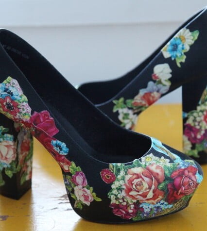 Svarta högklackade skor dekorerade med blommiga bokmärken.