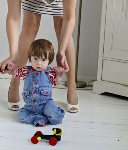 Sonen Bertil på golvet som riktigt liten, Clara håller i hans händer.