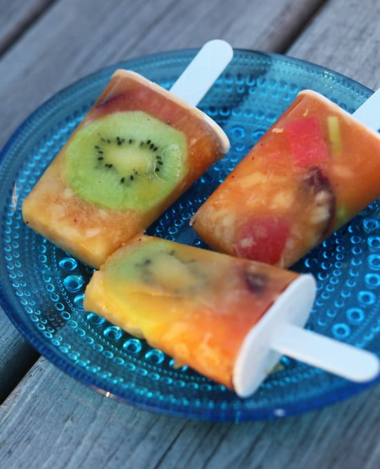 Isglass där frukterna som fryst in i pinnen syns tydligt, kiwi och körsbär.