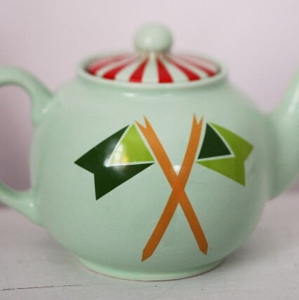 Liten rund tekanna som dekorerats med mönster i olika färger.