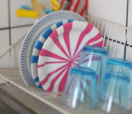 Vita tallrikar som dekorerats med rosa och blå ränder.