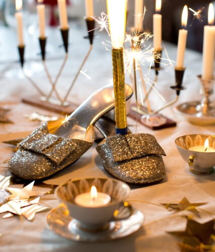 Festsko i silverglitter som en del av dukningen på ett nyårsbord.