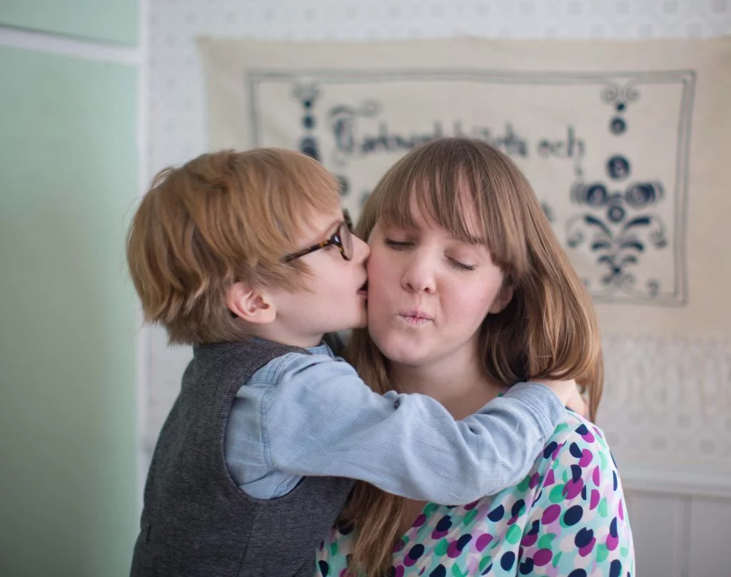 Clara får puss på kinden av sonen Bertil som hon håller i famnen.