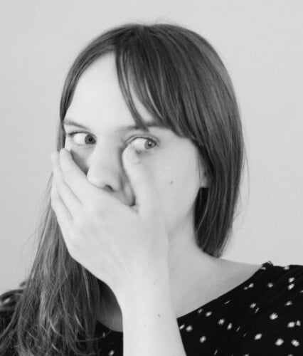 Clara håller handen för munnen.