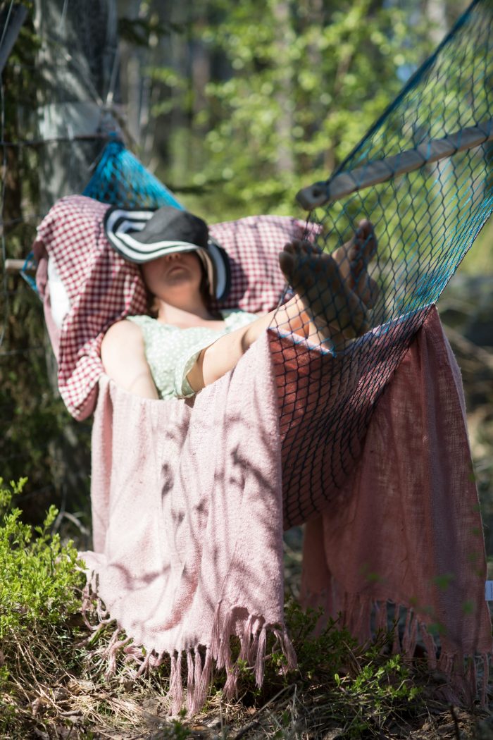 Clara ligger och vilar under solhatt i en hängmatta. Från En Underbar Pod.