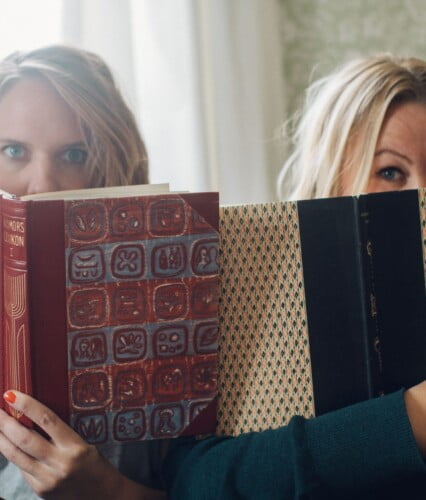 Clara och Erica sitter med näsorna djupt försjunkna i varsin bok. Ur En Underbar Pod.